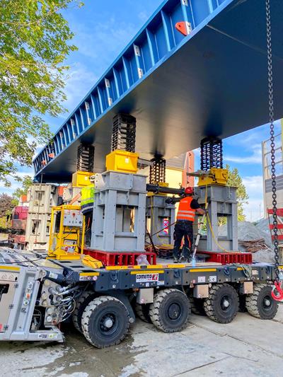 When the operator received the message "component in correct position" on the theodolite, the SPMT lowered itself and set the bridge down on its supports.